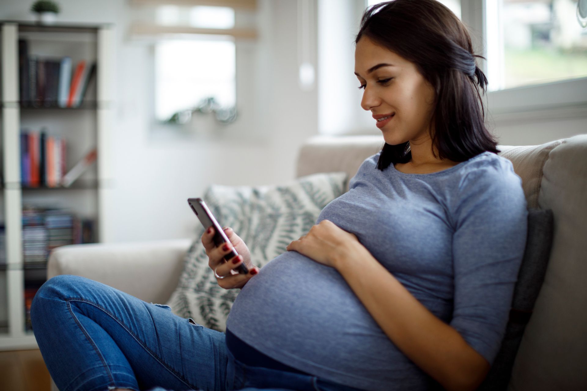 Pregnant woman smiling and touching her belly