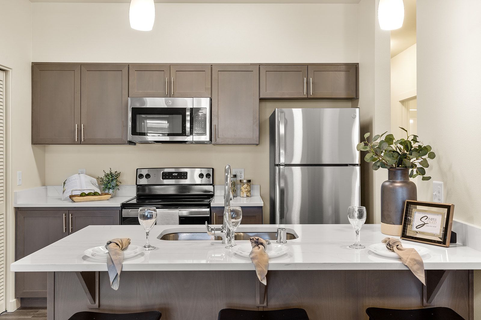 Modern kitchen with stainless appliances, white island, and simple decor