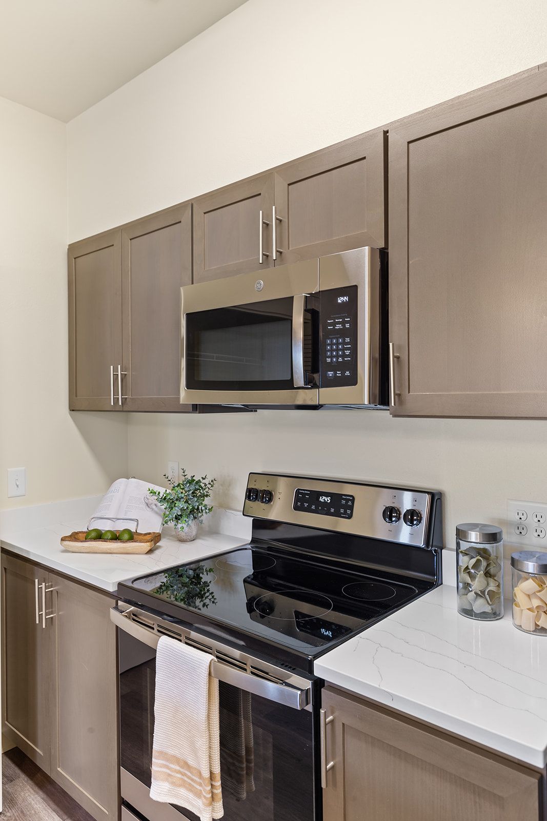 Modern kitchen with tan cabinets, stainless steel appliances, and white countertops