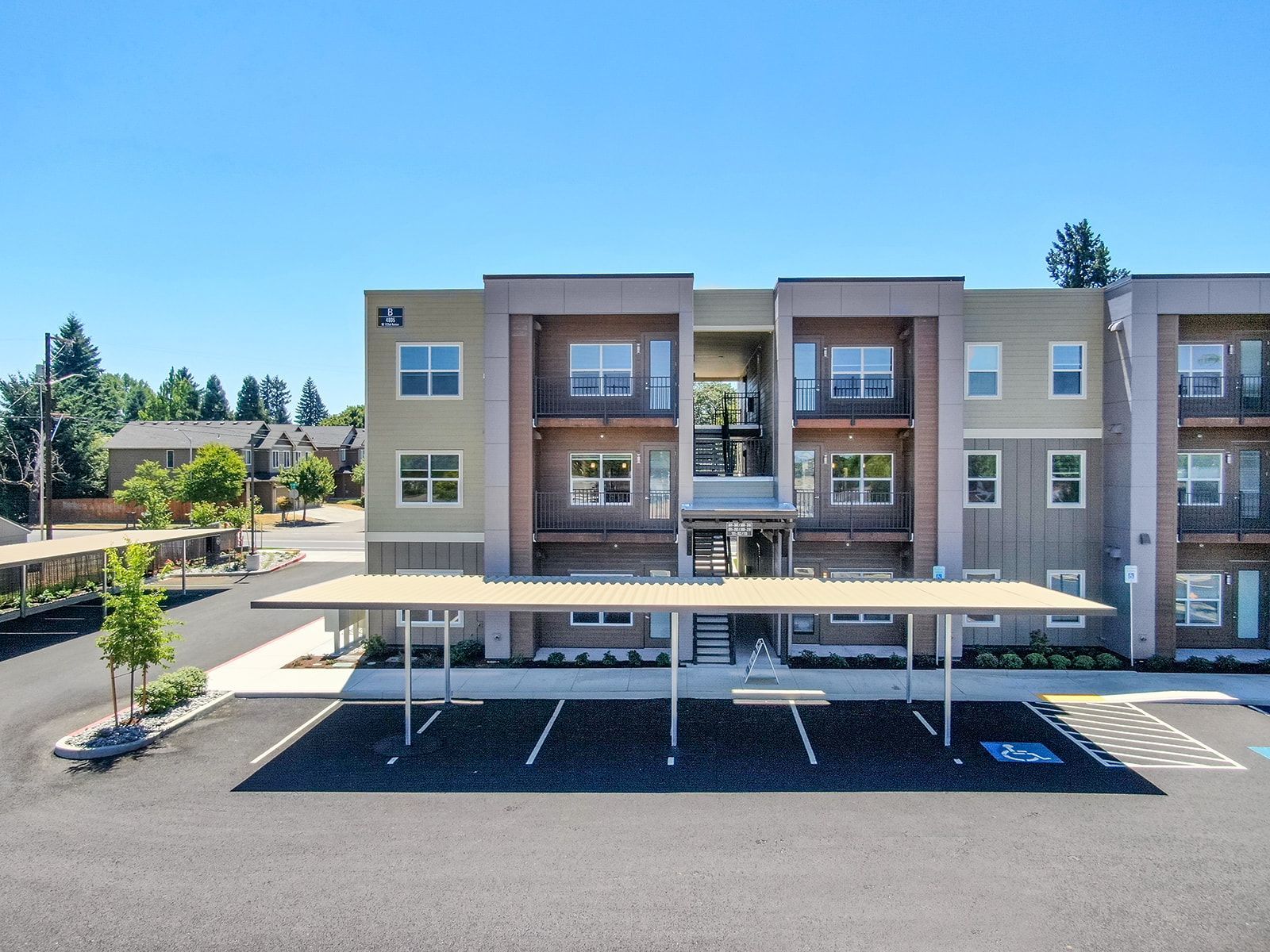 Modern apartment building with covered parking on a sunny day