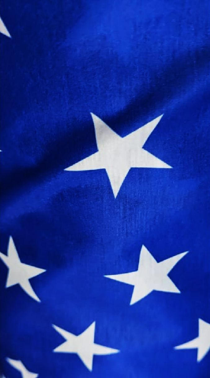 Tela azul con estrellas blancas, de cerca; probablemente una parte de la bandera estadounidense.