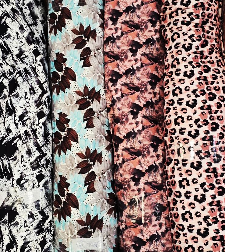 Rollos de tela estampada: abstracto en blanco y negro, floral en azul, melocotón/negro y estampado de leopardo.