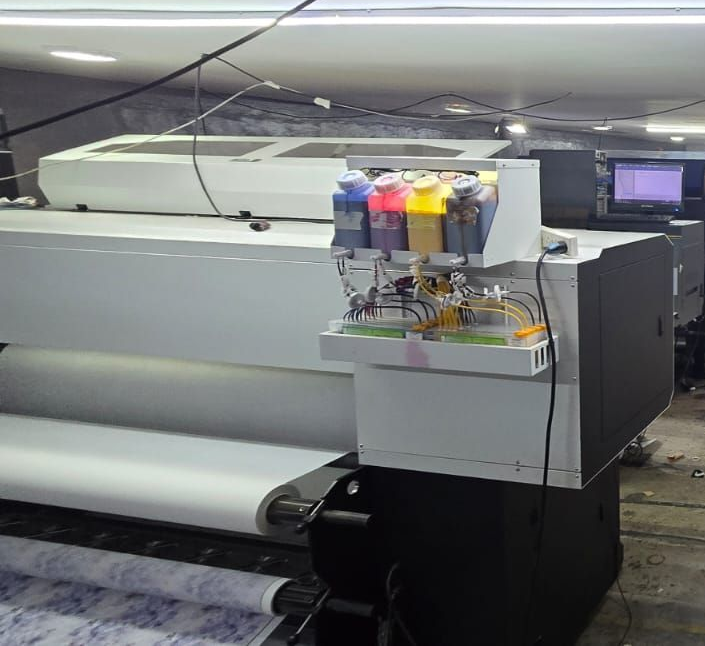 Impresora de gran formato con tanques de tinta en una imprenta.
