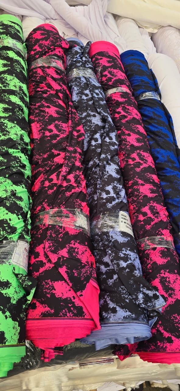 Pernos de tela enrollados en varios patrones de camuflaje digital, incluidos rosa, azul, verde y negro.