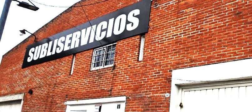 Edificio de ladrillo con un cartel negro que dice