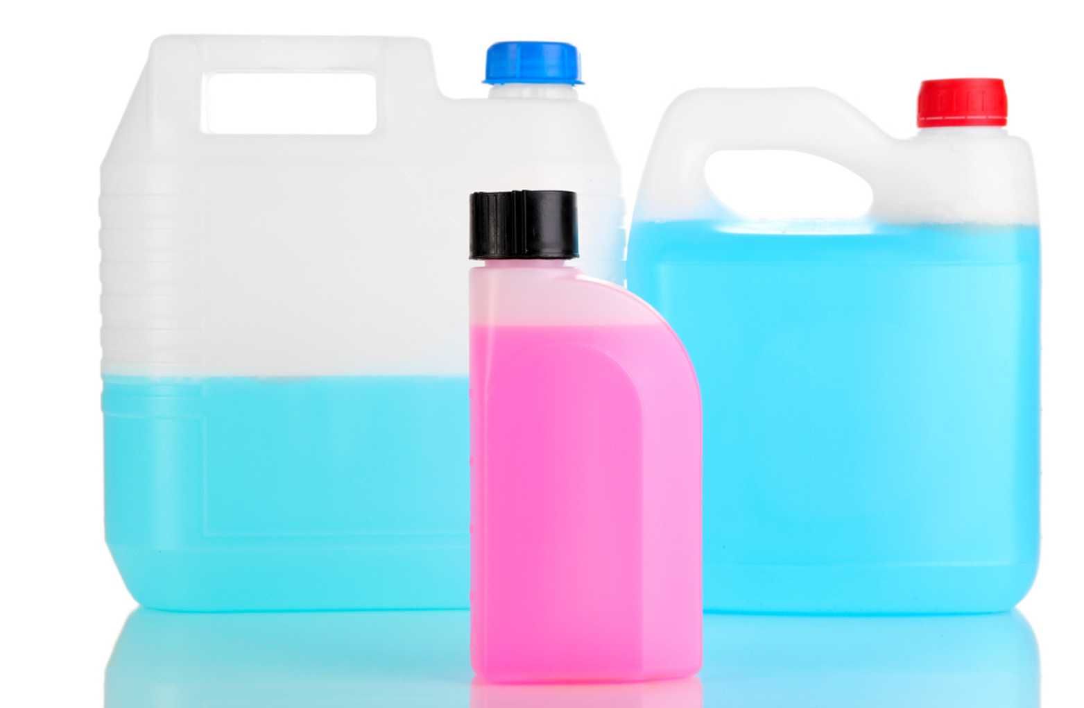 Plastic detergent bottles with blue and pink liquid on a white background