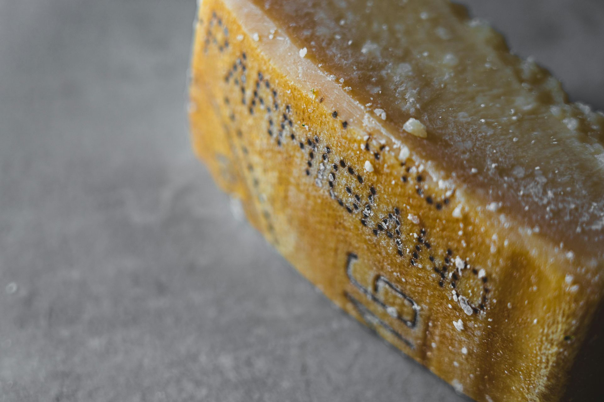 Close-up of a frosted beer bottle neck on a gray surface, with yellow label and visible condensation