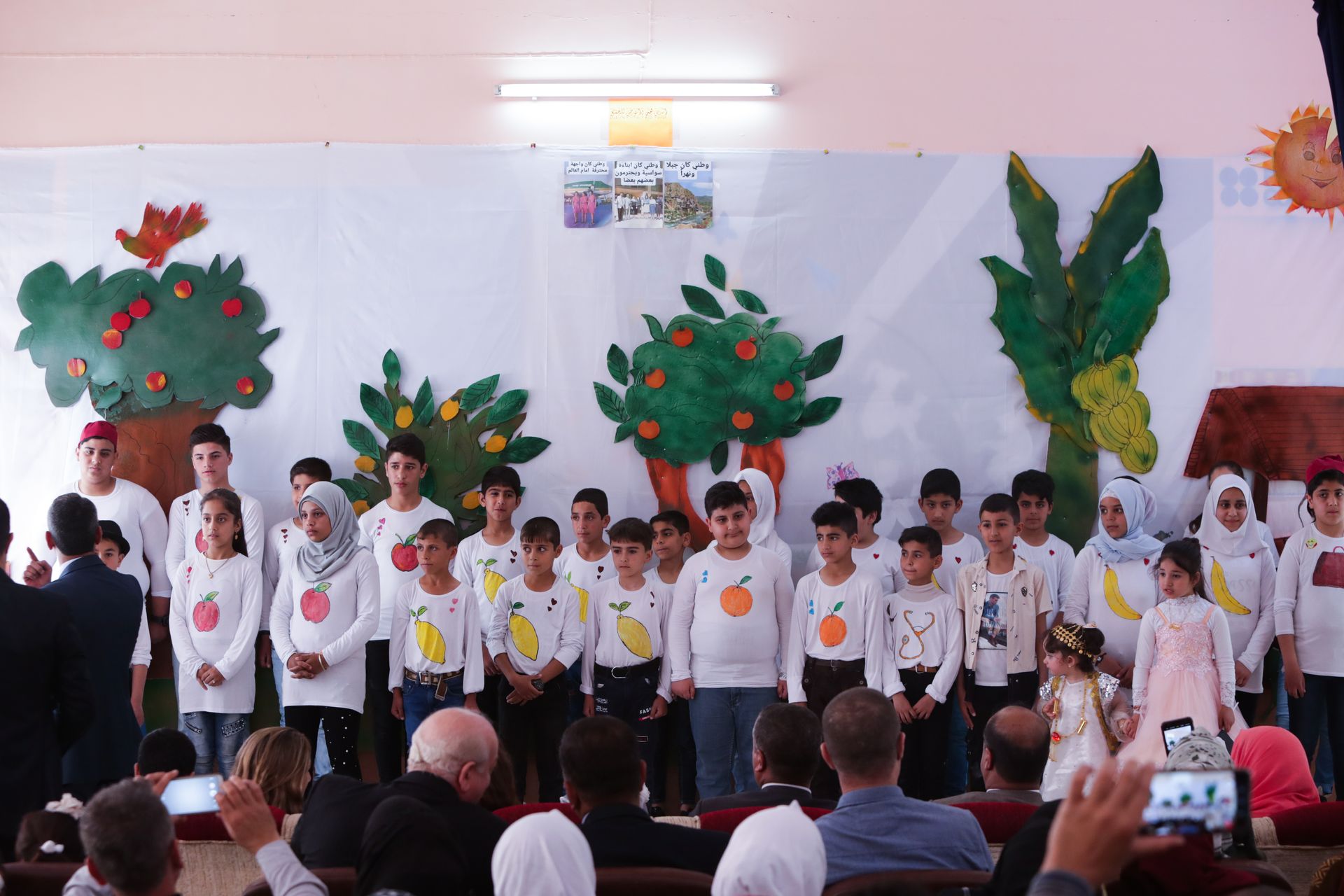 Human Rights Programs: A group of children are standing in front of a wall with trees painted on it