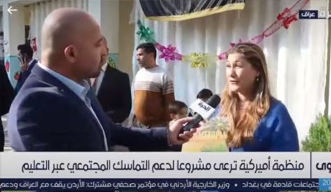 Non Profit: A man is talking to a woman with a microphone.