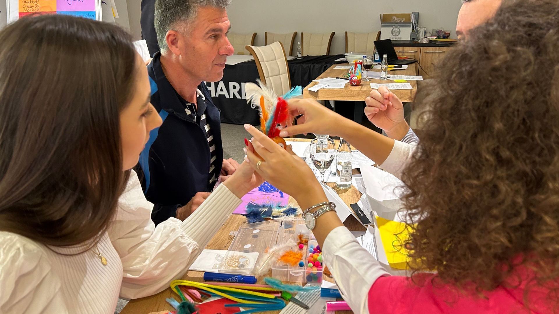 Religious Freedom Organization: A group of people are sitting at a table making crafts.