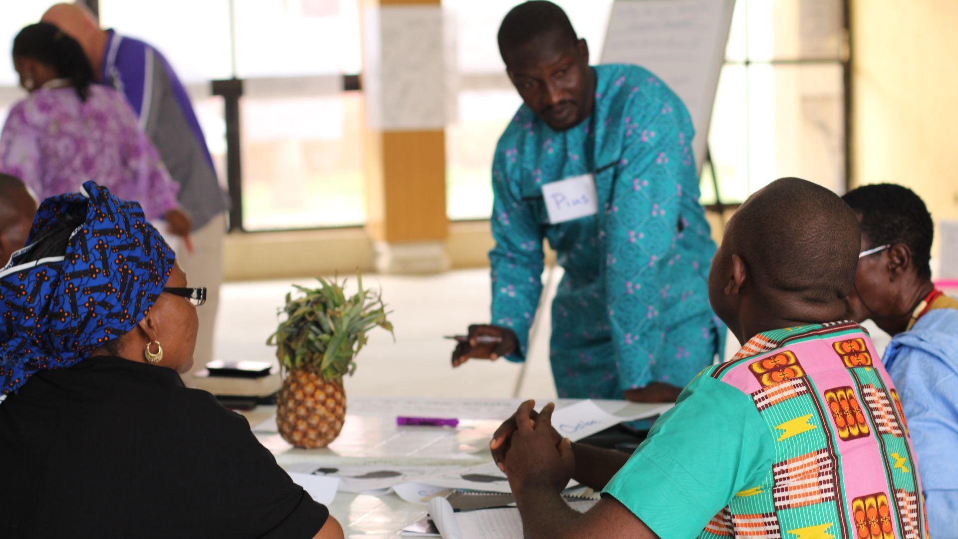 Non Profit Organization for Human Rights: A group of people are sitting around a table with a pineapple on it.