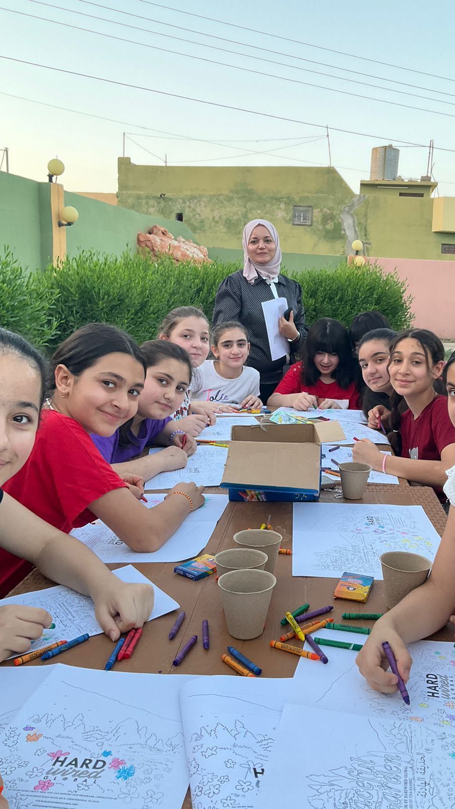 Religious Freedom Organization: A group of young girls are sitting around a table drawing with crayons.