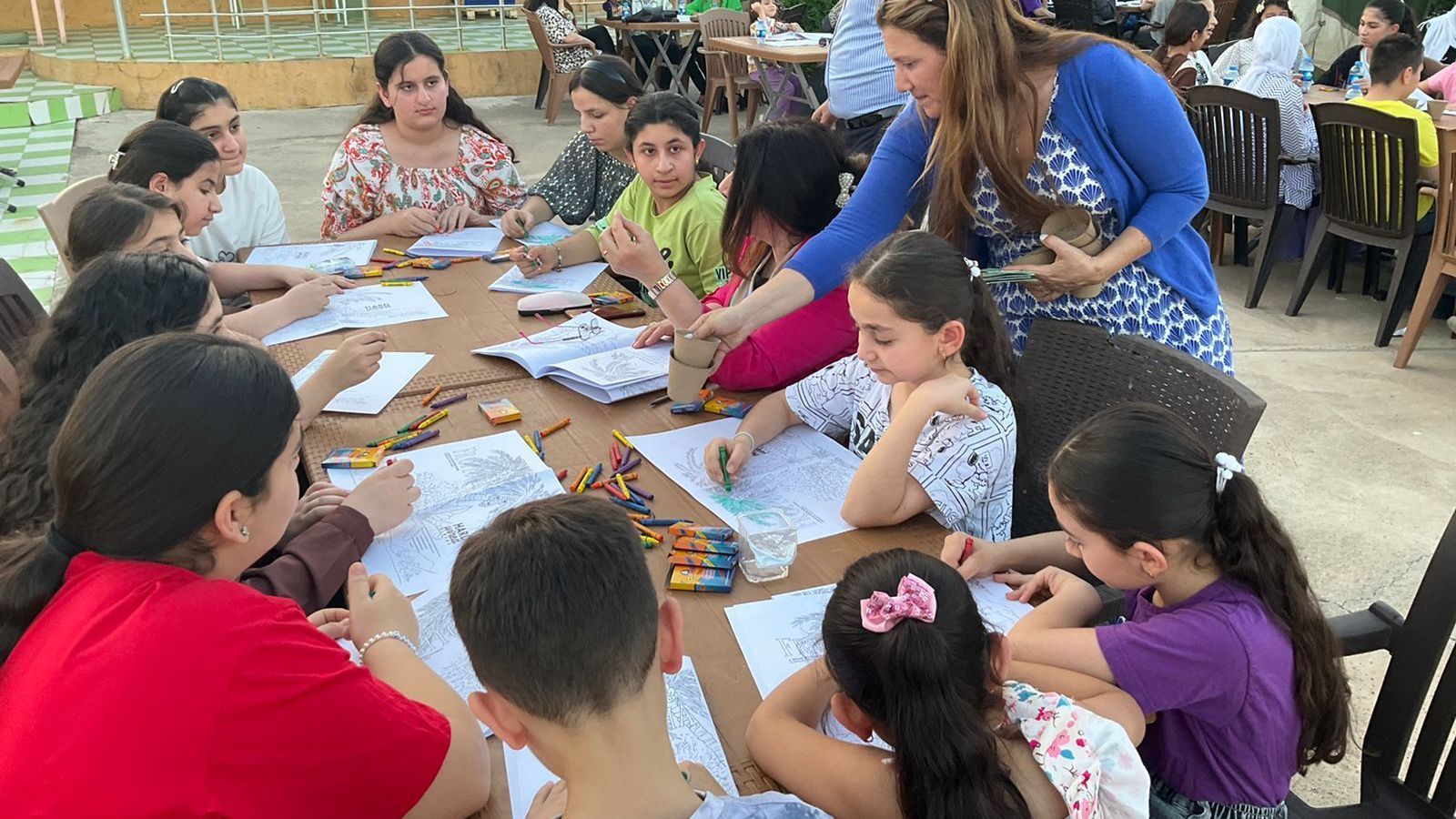 Religious Freedom Organization: A group of children are sitting around a table drawing with crayons.