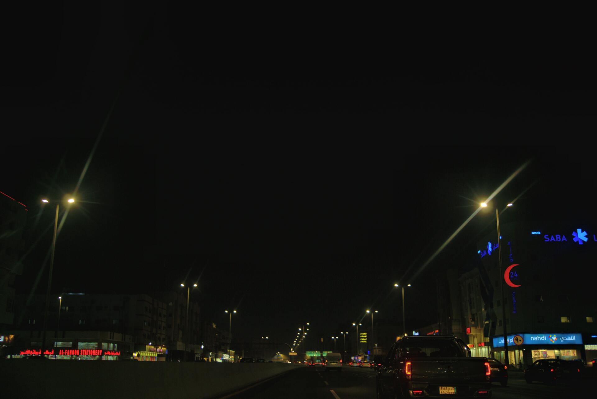 Nighttime street scene with illuminated streetlights and building lights.