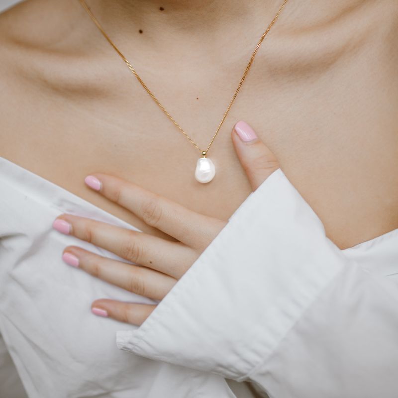 woman wearing a gold necklace