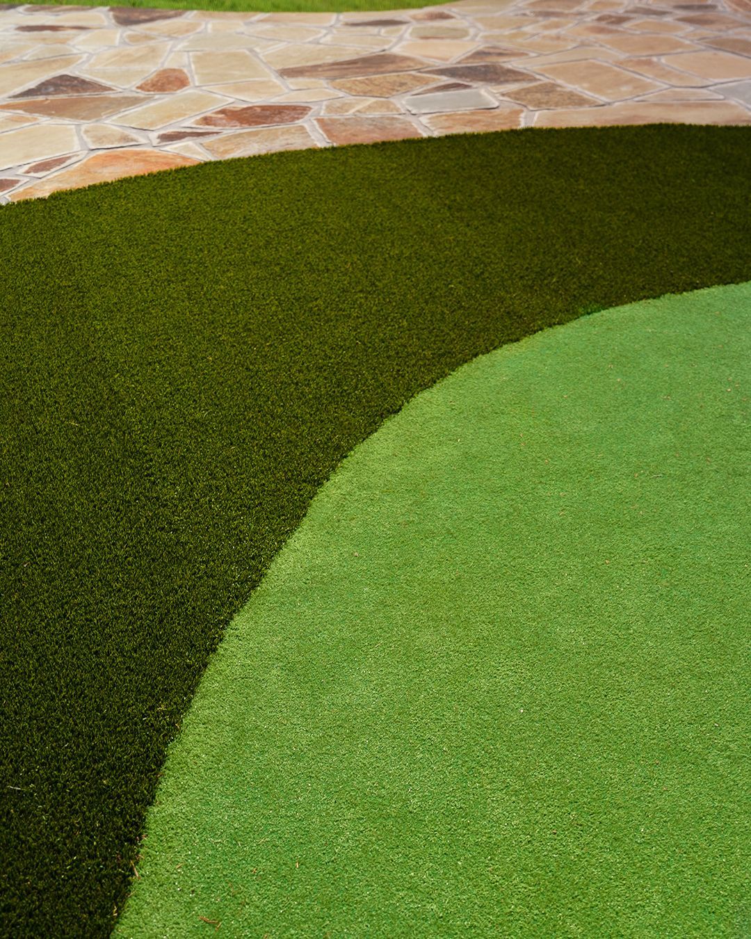 Curved green turf beside a stone-tiled path