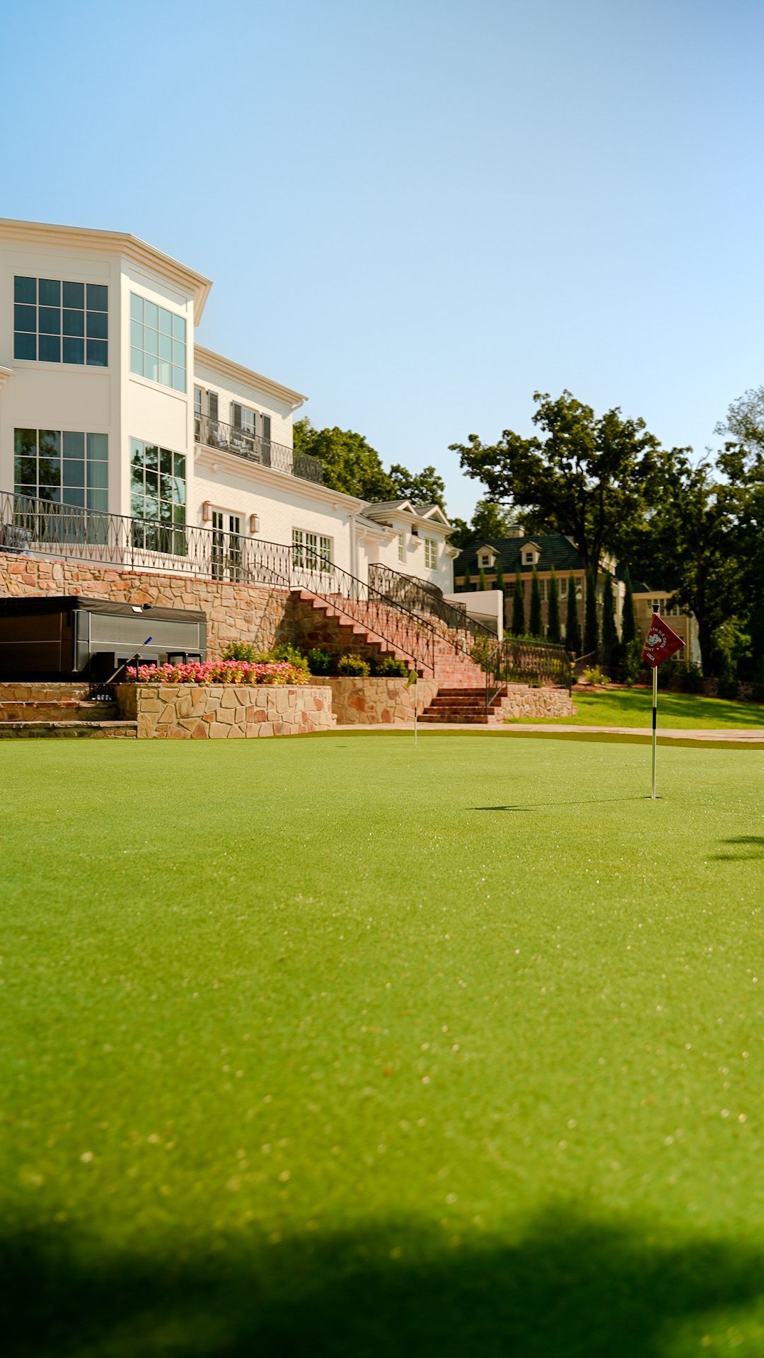 White building beside a green lawn under a clear blue sky