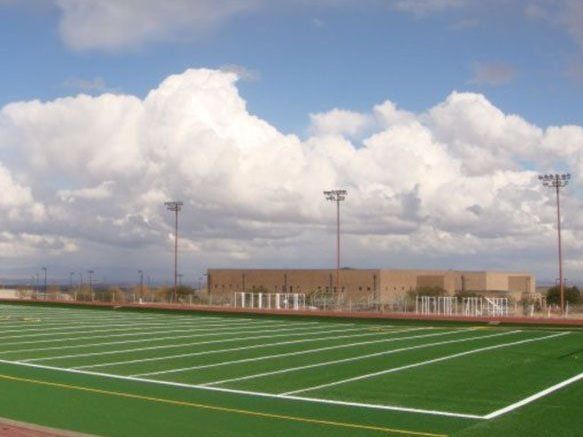A football field with a blue sky and clouds in the background
