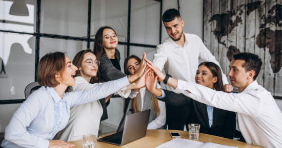 Equipe em reunião comemorando com um 