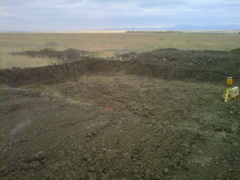 Wide barren rocky landscape under a cloudy sky, with a small yellow object at right.