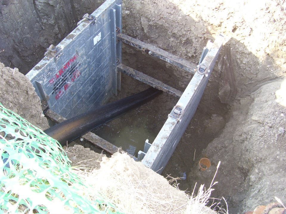 Open trench with metal shoring supports inside an excavation site