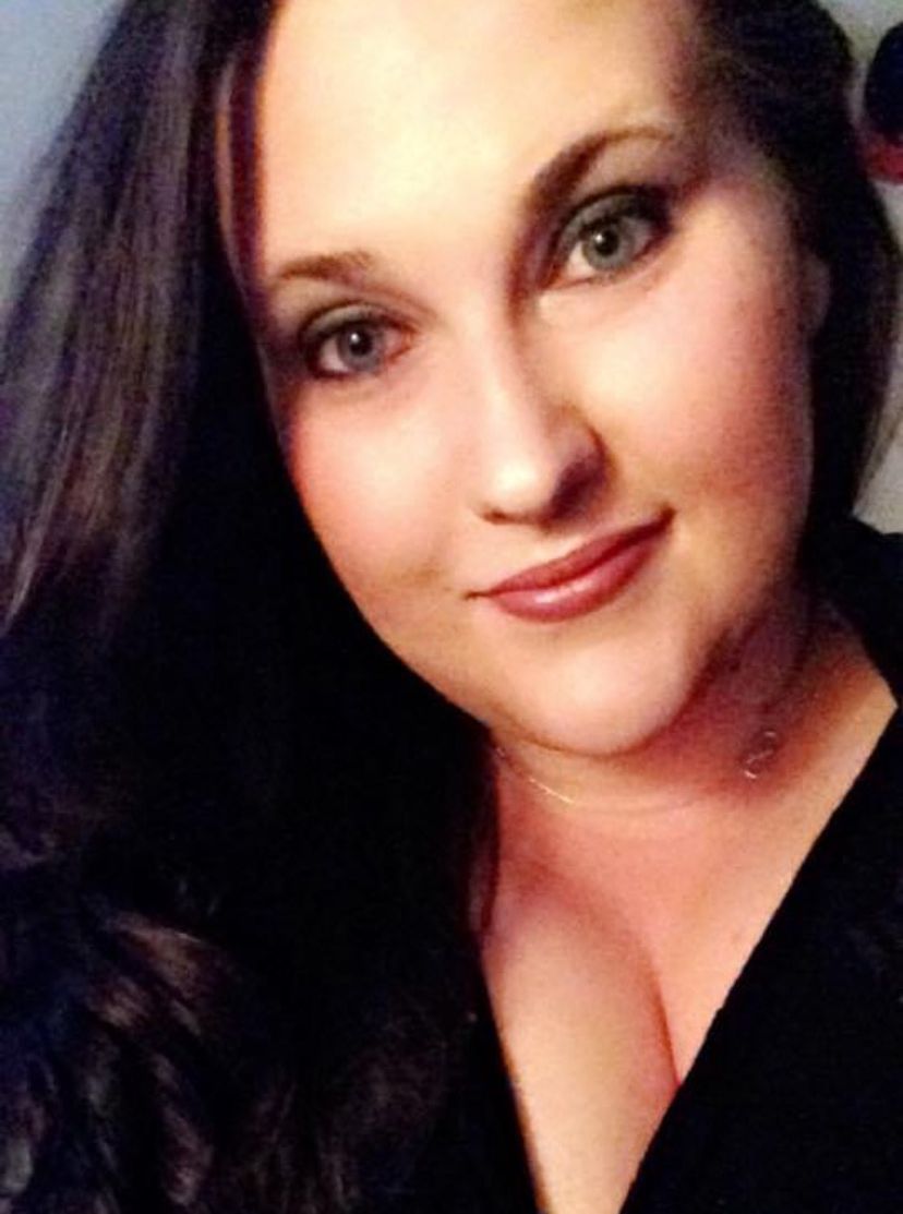 A close up of a woman 's face with long hair and a black shirt.