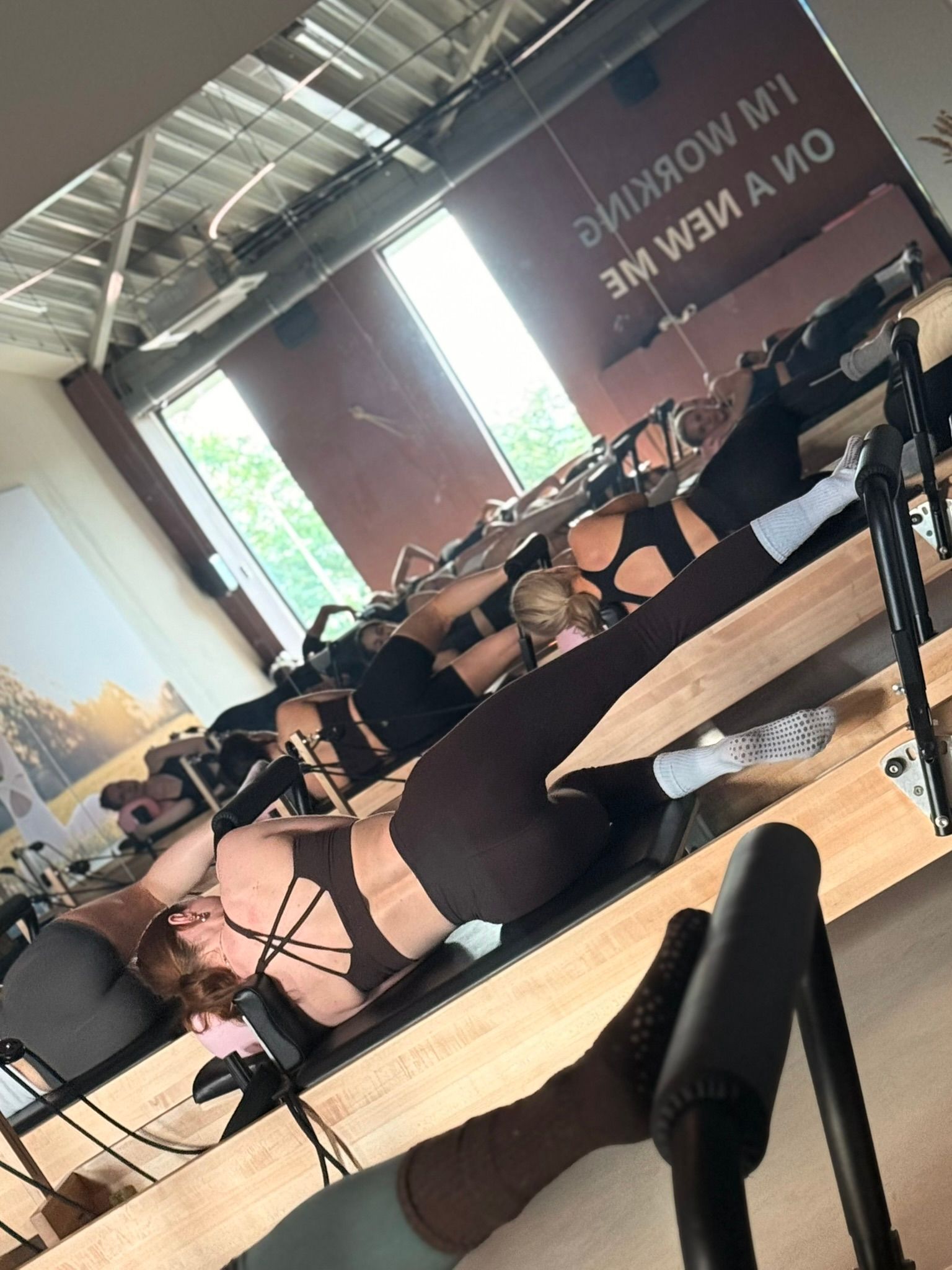 Massagestoelen in een lichte spa-ruimte met een groot raam en spiegels, vanuit een bepaalde hoek gezien.