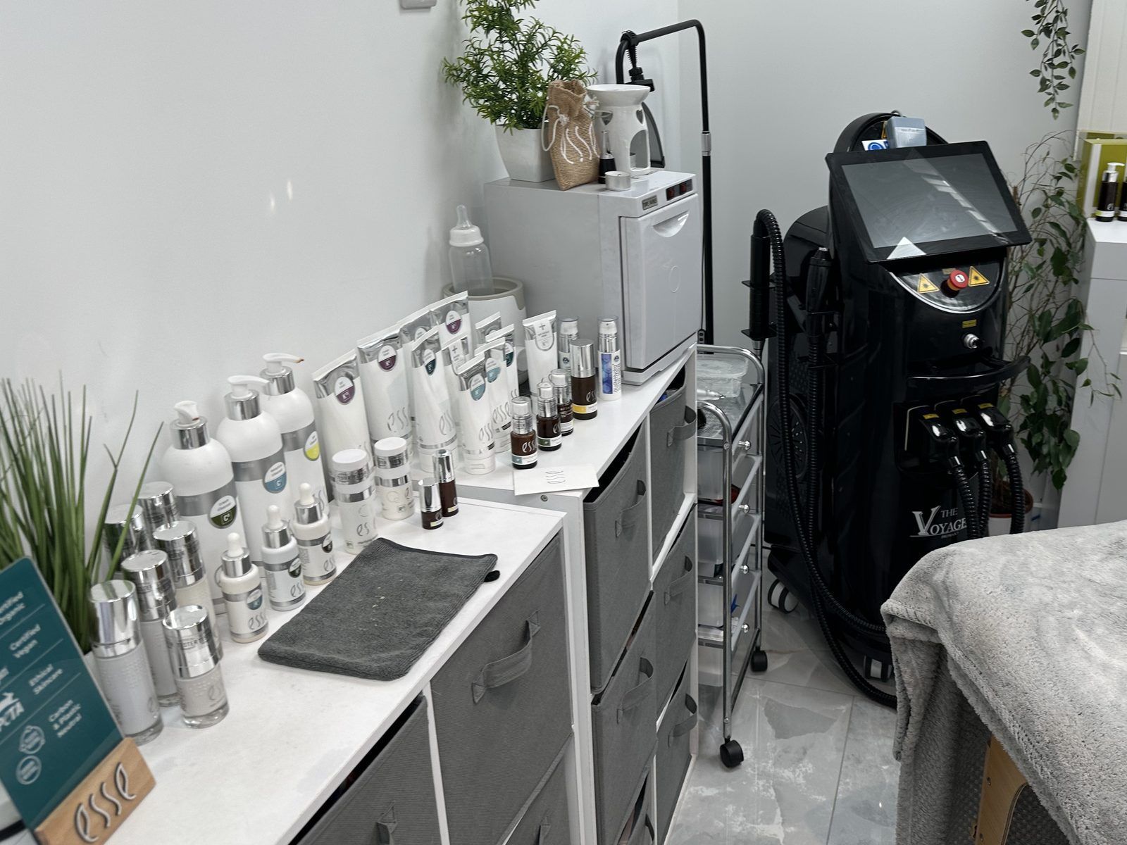 Treatment room at The Skinutrition Clinic in Coventry, with Esse skincare products, the laser platform and a treatment couch
