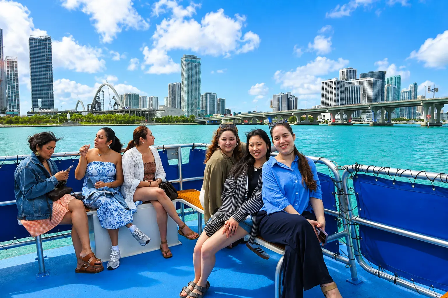 Visitors enjoying a Celebrity Mansion Boat Cruise in Miami with Miami Beach skyline views across Biscayne Bay