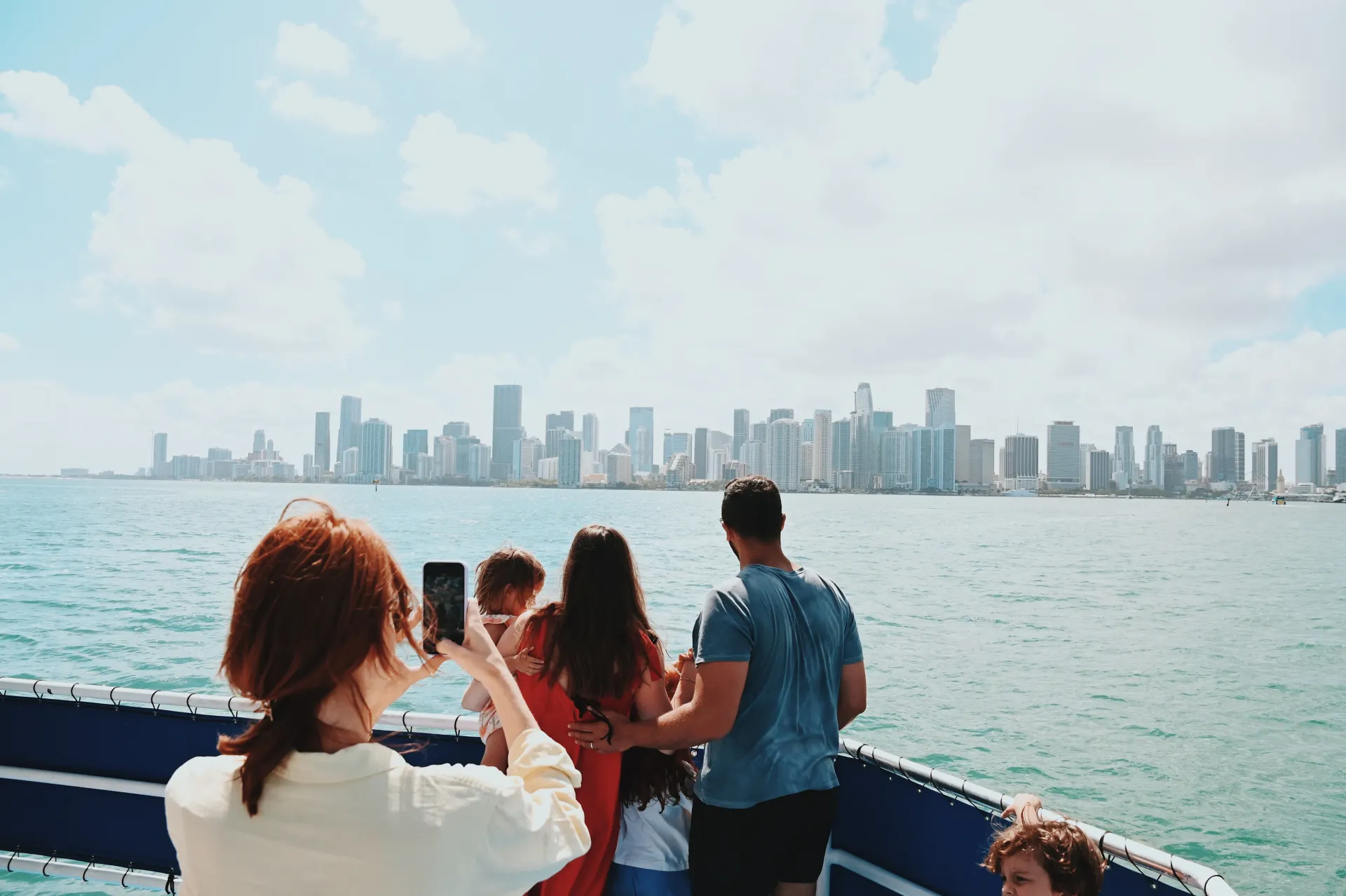 Guests enjoying a celebrity mansion boat cruise in Miami with views of the Miami skyline and Biscayne Bay