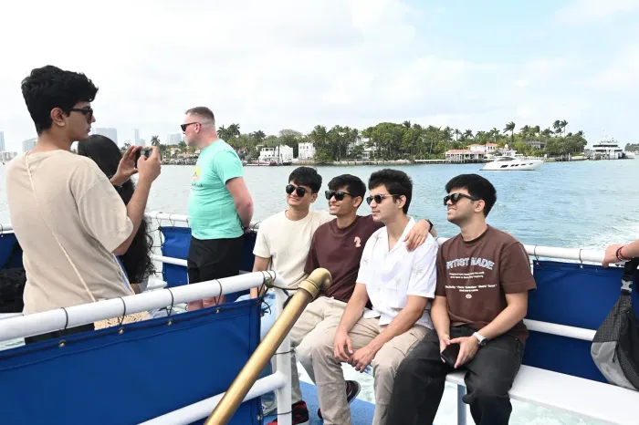 Guests enjoying a Miami Boat Tour on Biscayne Bay with celebrity homes and waterfront mansions in the background