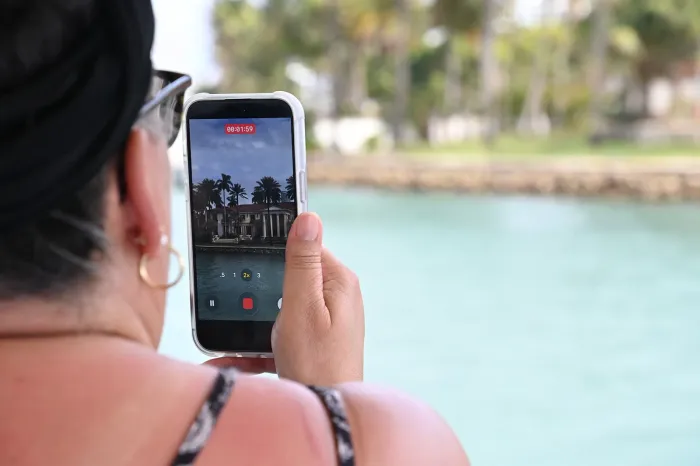 guest taking photos of celebrity homes during Miami Boat Tours sightseeing experience