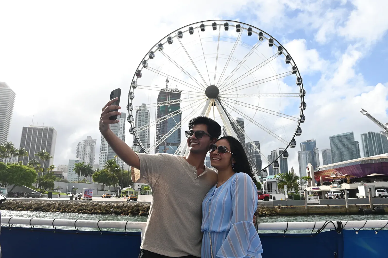 Couple taking a selfie during a Miami boat tour with Skyviews Miami and the Downtown skyline in the background