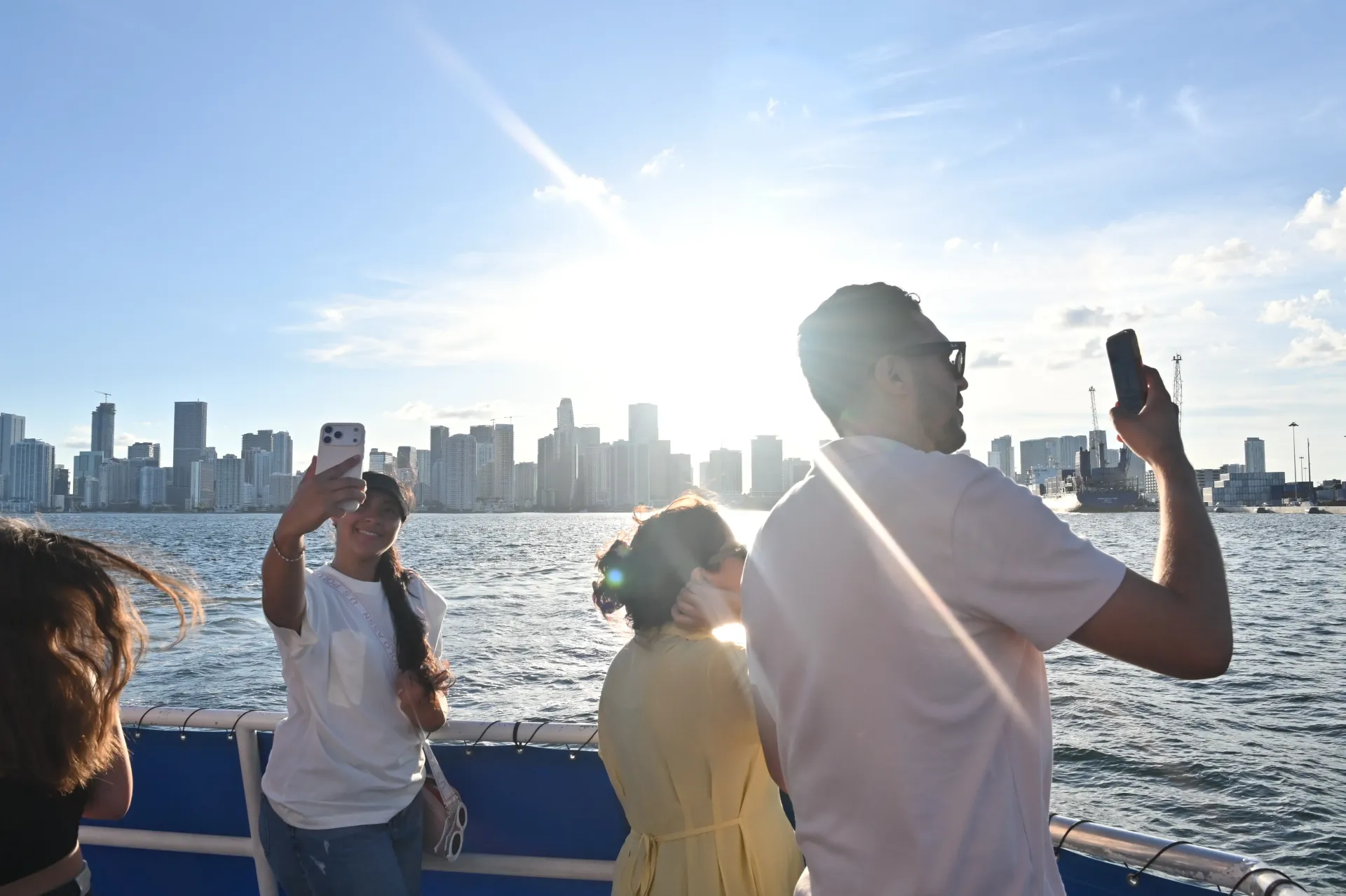 Miami Early Bird Special sightseeing cruise guests taking skyline photos on Biscayne Bay.