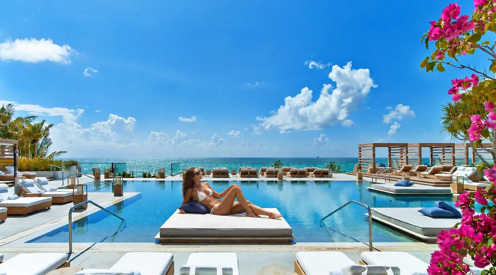 Relaxing by an oceanfront hotel pool during a Miami staycation.