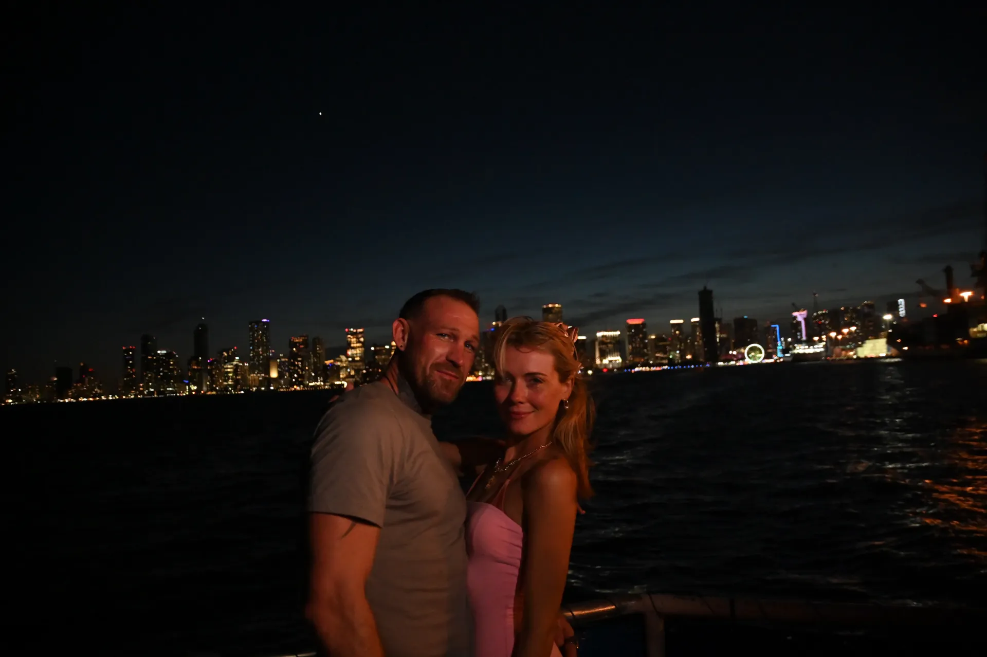 Couple enjoying the Miami night sightseeing route with the illuminated Miami skyline across Biscayne Bay.