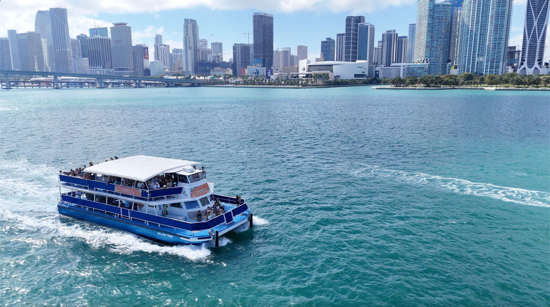 Miami Sightseeing Boat tour with the Miami Skyline Behind it