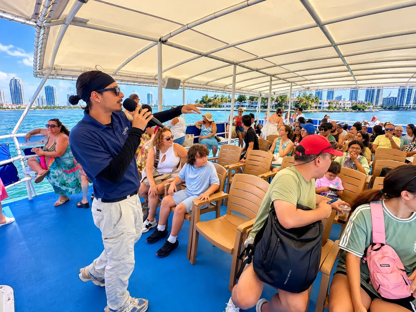 Miami sightseeing cruise guide providing live commentary to passengers aboard a Biscayne Bay boat tour, highlighting the guest experience discussed in customer reviews.