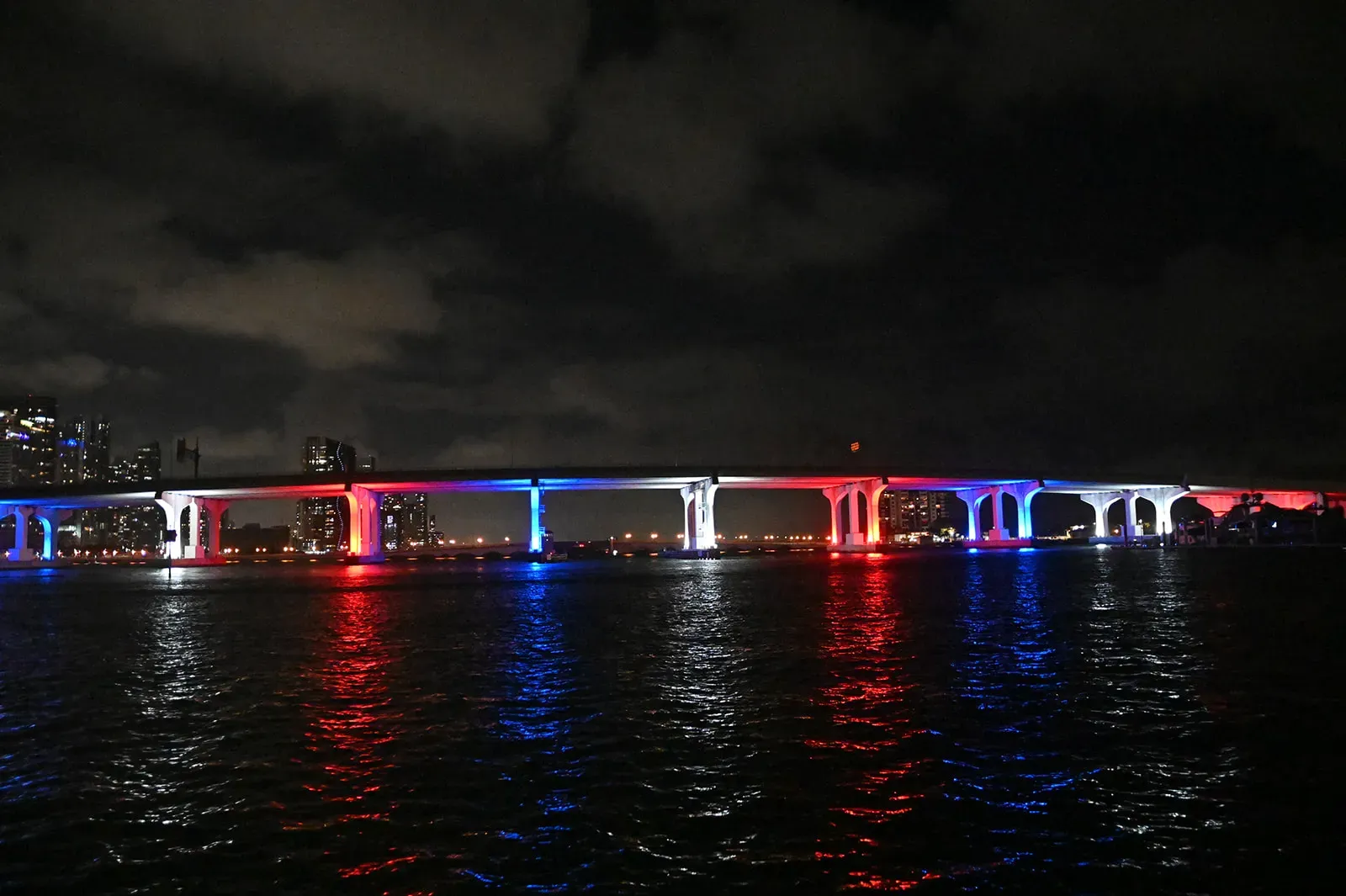 MacArthur Causeway lit at night during a Miami sightseeing cruise on Biscayne Bay