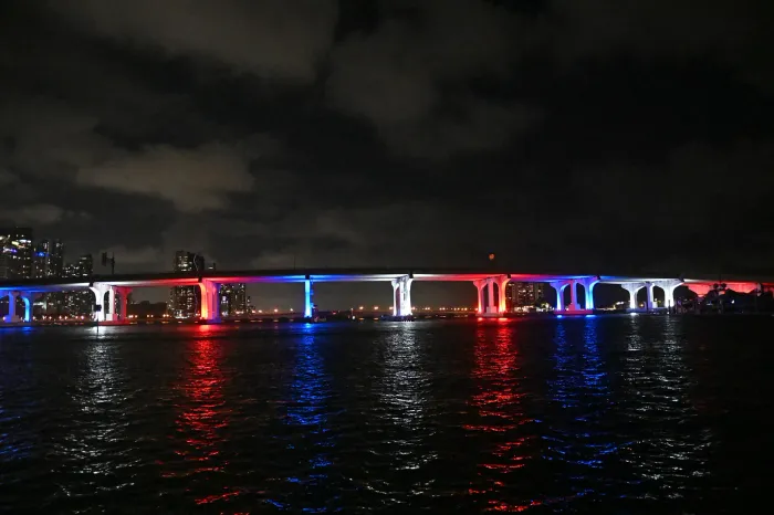 MacArthur Causeway lit at night during a Miami sightseeing cruise on Biscayne Bay