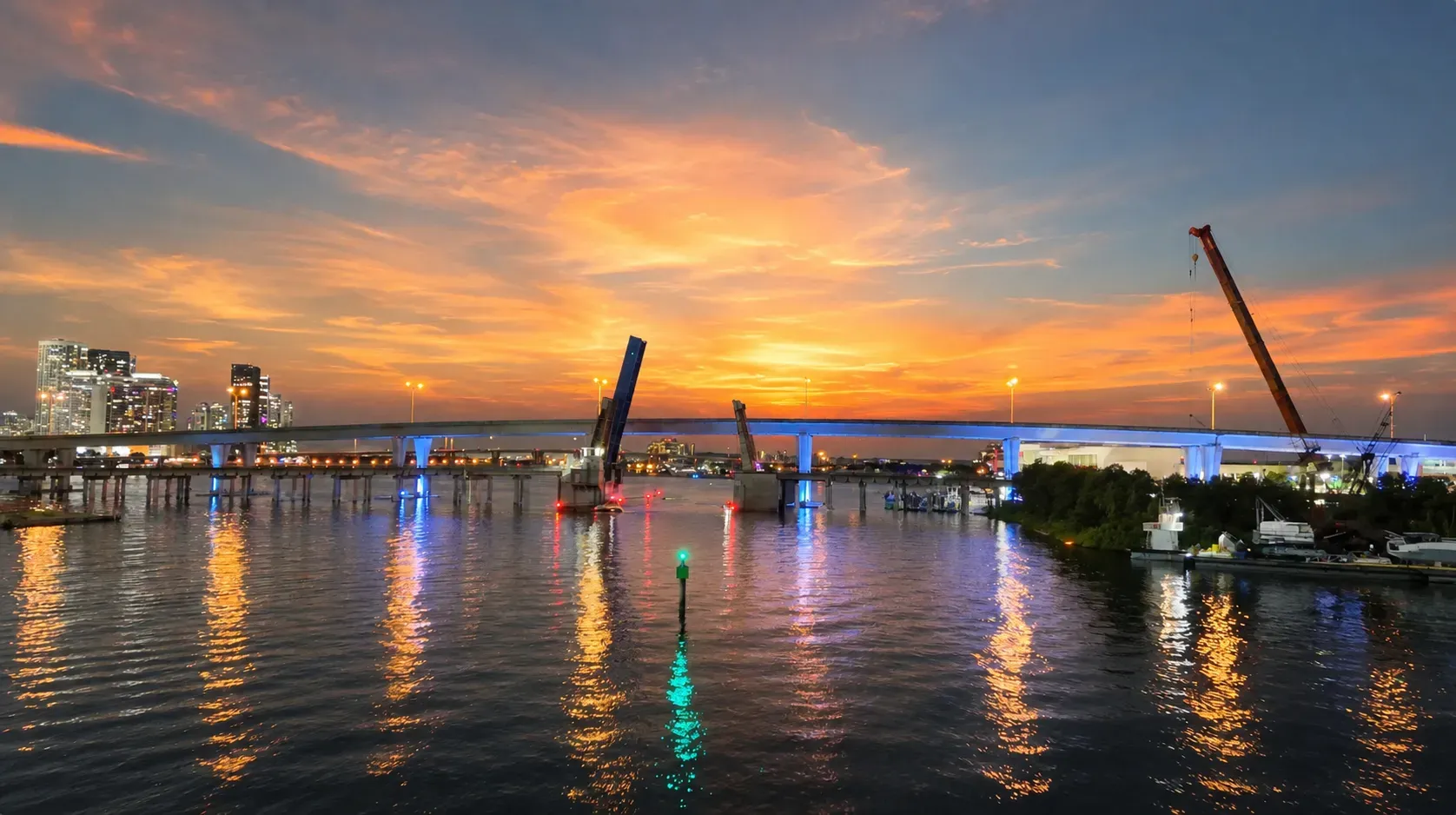 Miami Sunset Mansion Cruise passing the MacArthur Causeway during sunset with skyline reflections on Biscayne Bay
