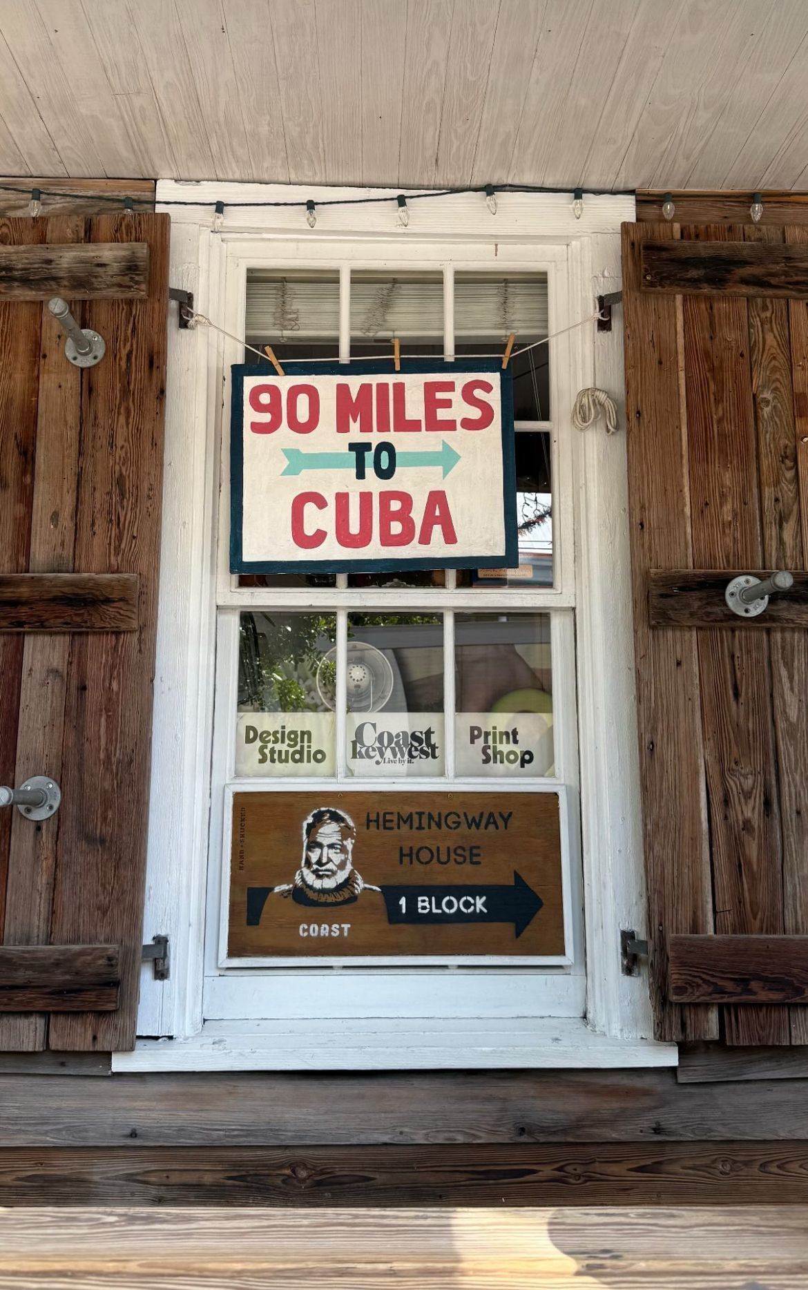 Handmade “90 Miles to Cuba” sign and Hemingway House direction sign in Key West