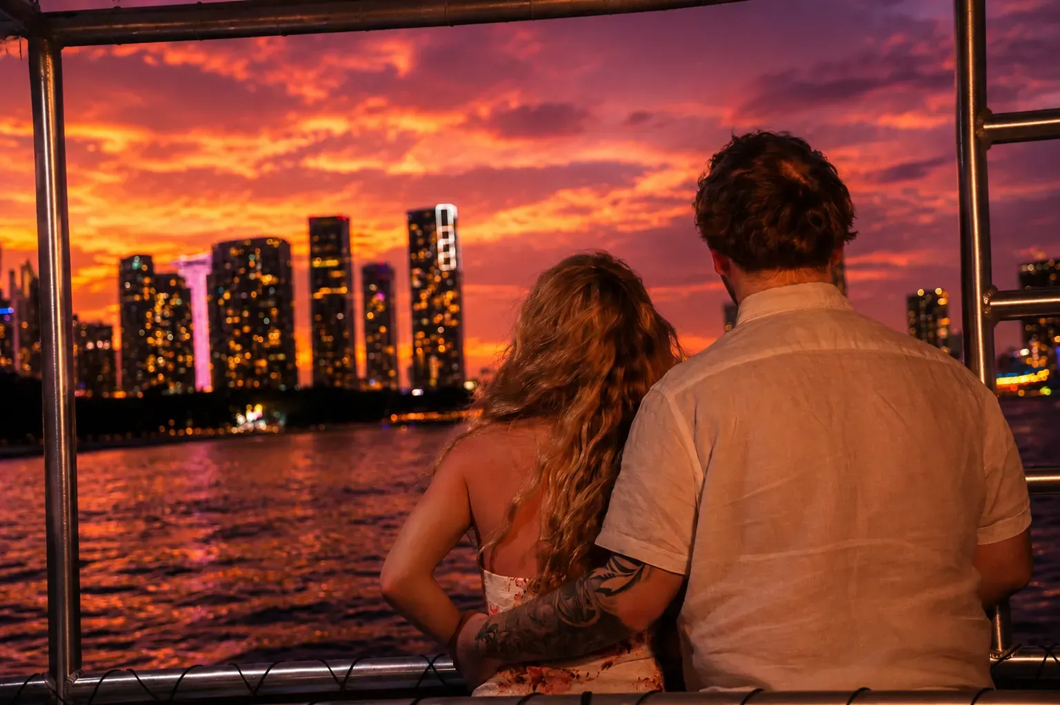 Couple enjoying a Miami Twilight Cruise with colorful skyline reflections and sunset views over Biscayne Bay