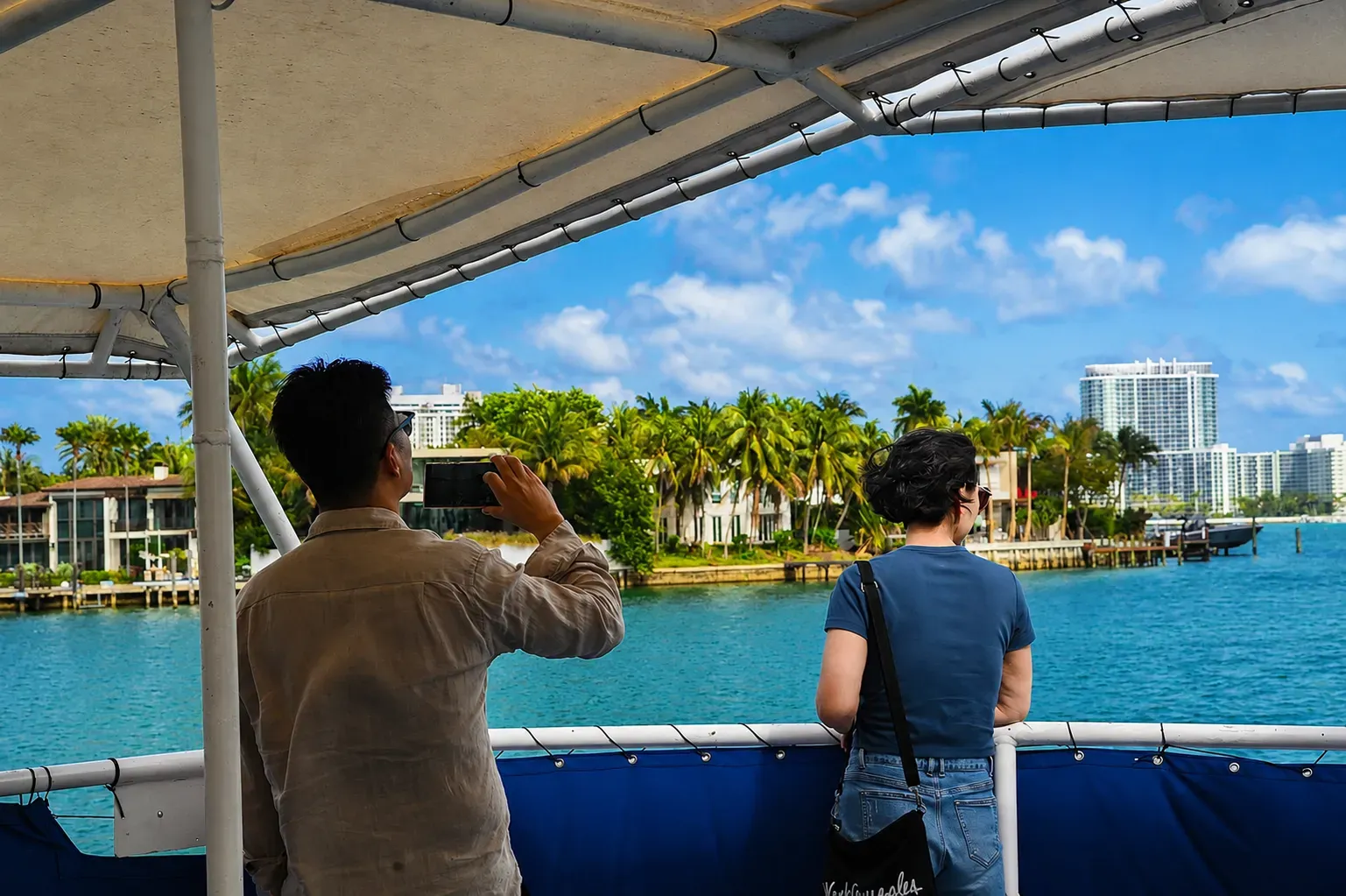 Visitors viewing Star Island Miami celebrity homes and waterfront estates from Biscayne Bay with the Miami skyline in the background