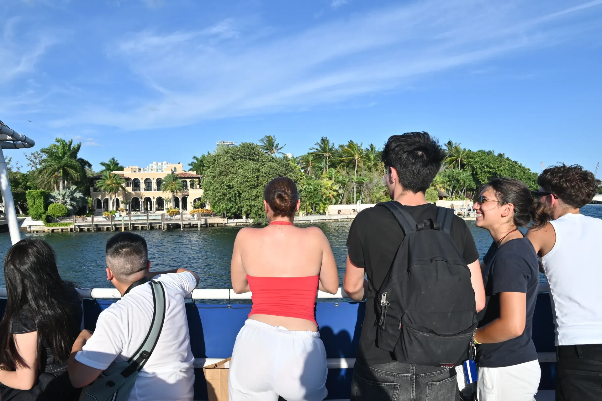 Guests enjoying the Star Island Miami route while viewing one of the waterfront celebrity mansions surrounded by tropical landscaping and luxury estates.