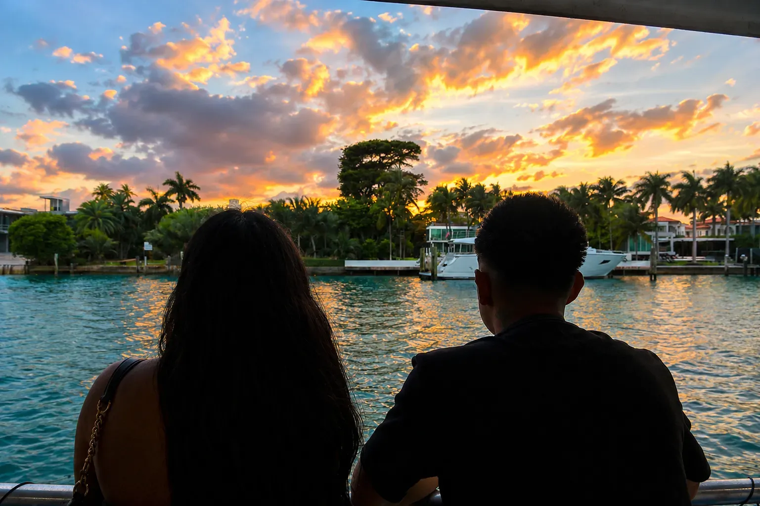 Couple enjoying sunset views near Star Island Miami with luxury waterfront estates, Biscayne Bay, and tropical scenery