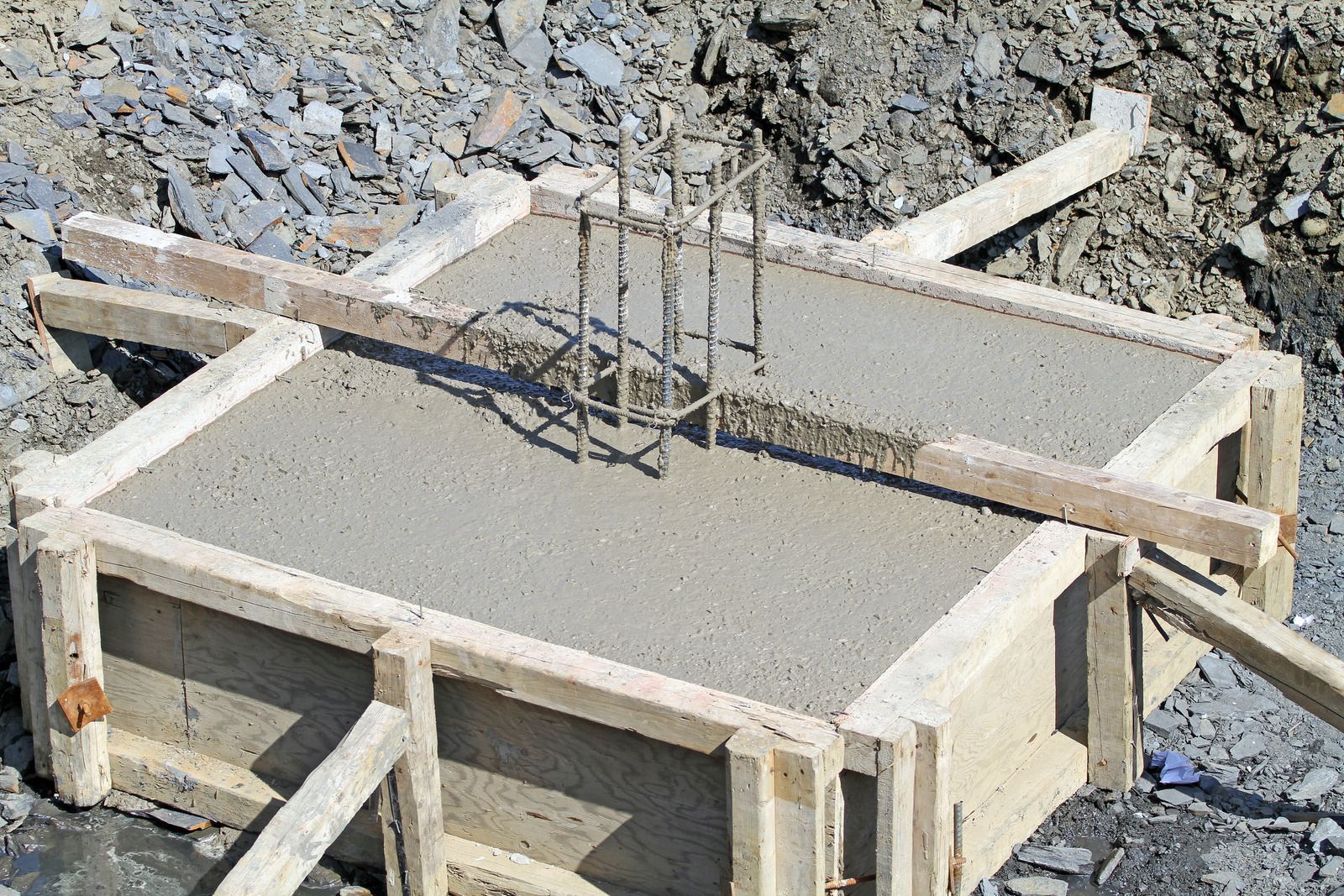Concrete foundation formwork with exposed rebar at a construction site