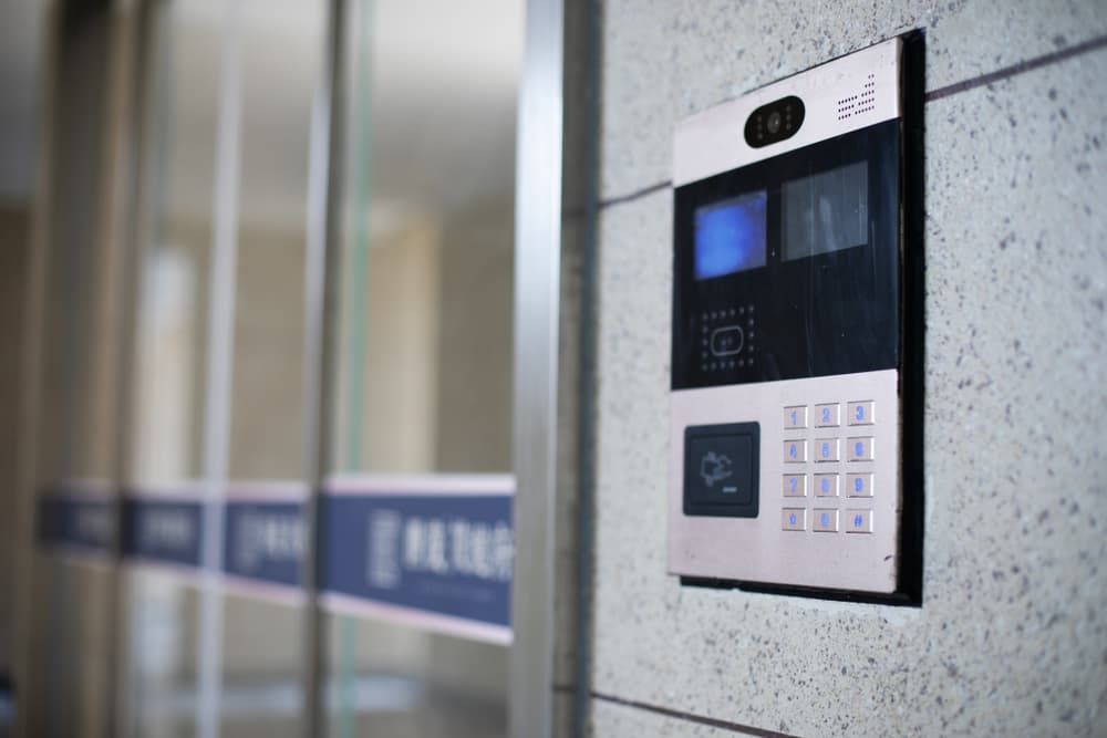 A Doorbell is Hanging on a Wall Next to a Glass Door — Coast & Hinterland Mobile Locksmiths In Noosaville, QLD
