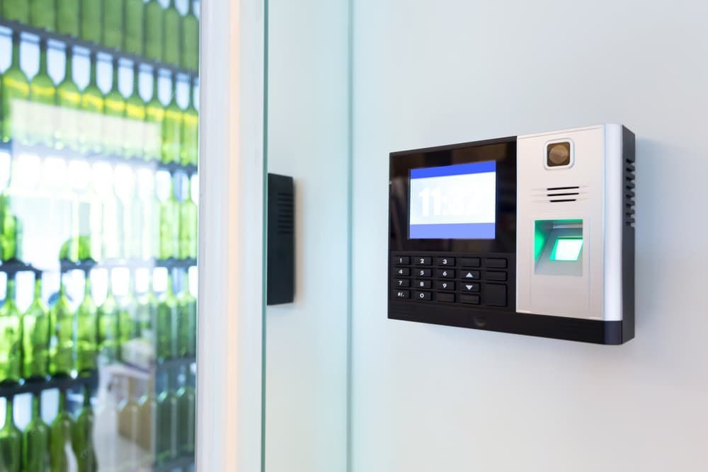 A Fingerprint Scanner is Hanging on a Wall Next to a Glass Door — Coast & Hinterland Mobile Locksmiths In Noosaville, QLD