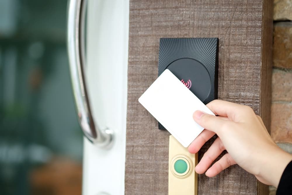 A Person is Inserting a Card Into a Door Lock — Coast & Hinterland Mobile Locksmiths In Noosaville, QLD